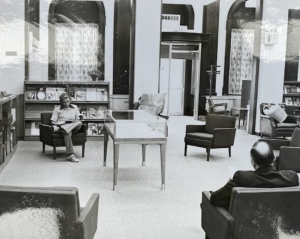 Black and white photograph of the inside of the library in the 1960s and 70s showing patrons reading in arm chairs