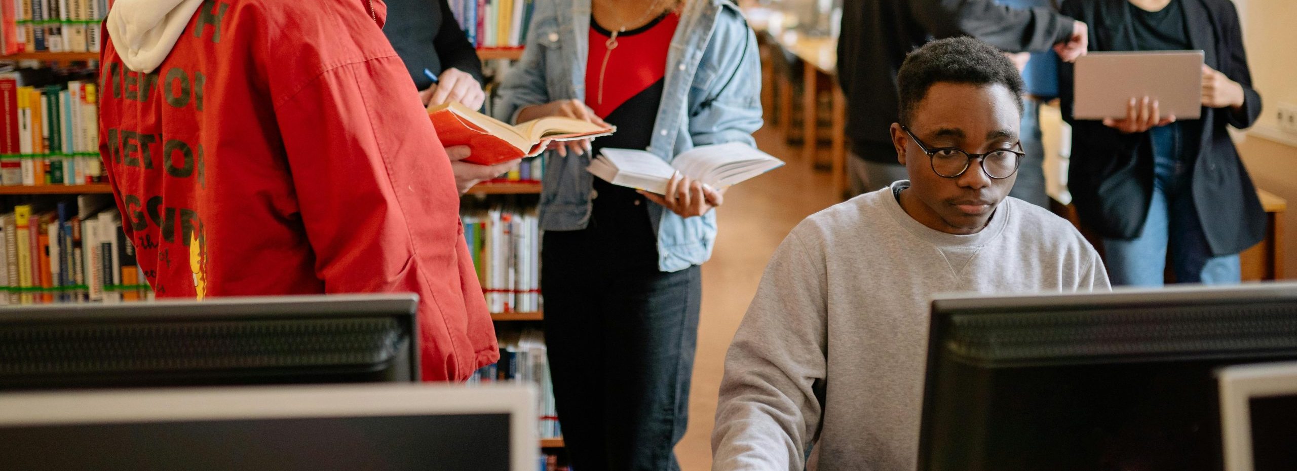 Students collaborating and studying in a library, fostering education and diversity.